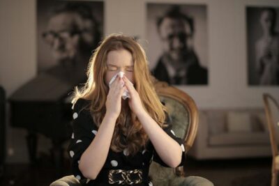 Sick Woman Wiping Her Nose with Tissue
