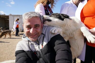 Dog Licking Smiling Man in Jacket
